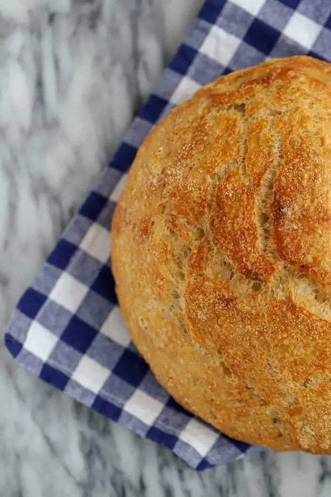 Overhead knead not sourdough bread on blue and white cloth napkin on a marble surface