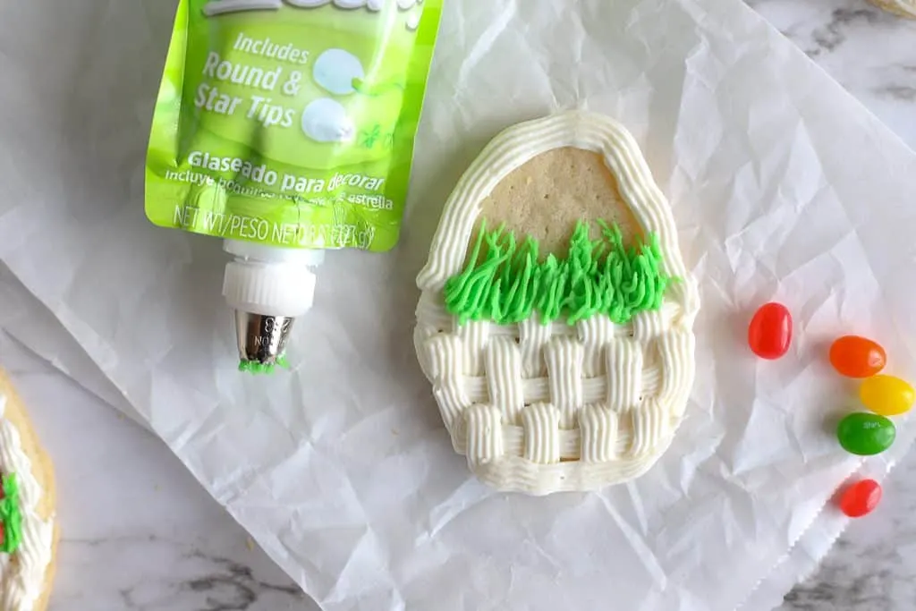 partially decorated egg cookie with green icing for grass