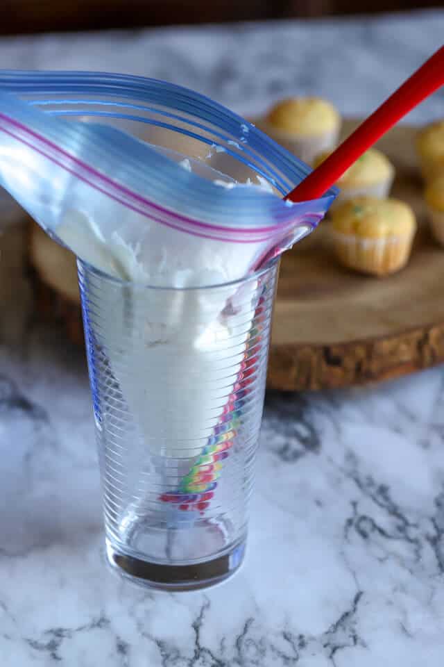 Fill an icing bag by placing it in a cup and use a spatula