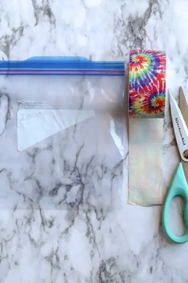 Ziploc Freezer Bag with duck tape and scissors on a marble countertop