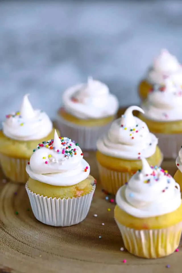 Mini cupcakes iced with white icing and colorful sprinkles