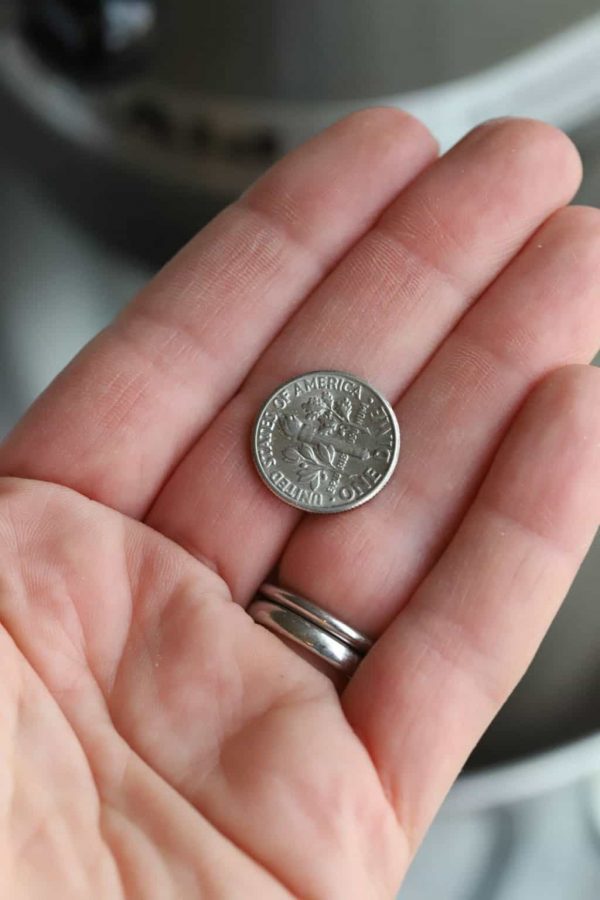 A dime in the palm of a hand in coordination for the dime test for kitchenaid mixer