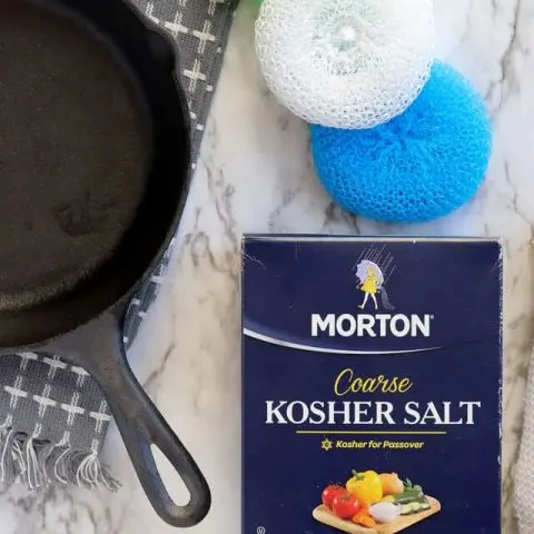 Cast iron pan with kosher salt and nylon scrub brush