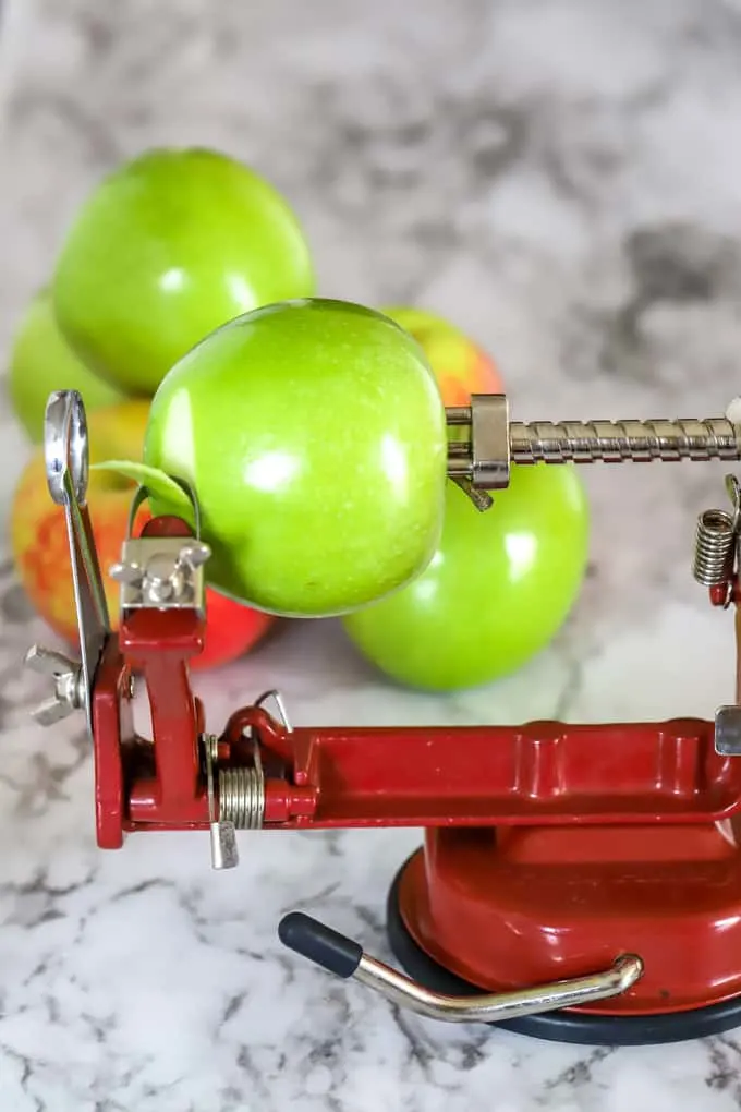 Apple peeler and corer device with granny smith apple ready to be peeled