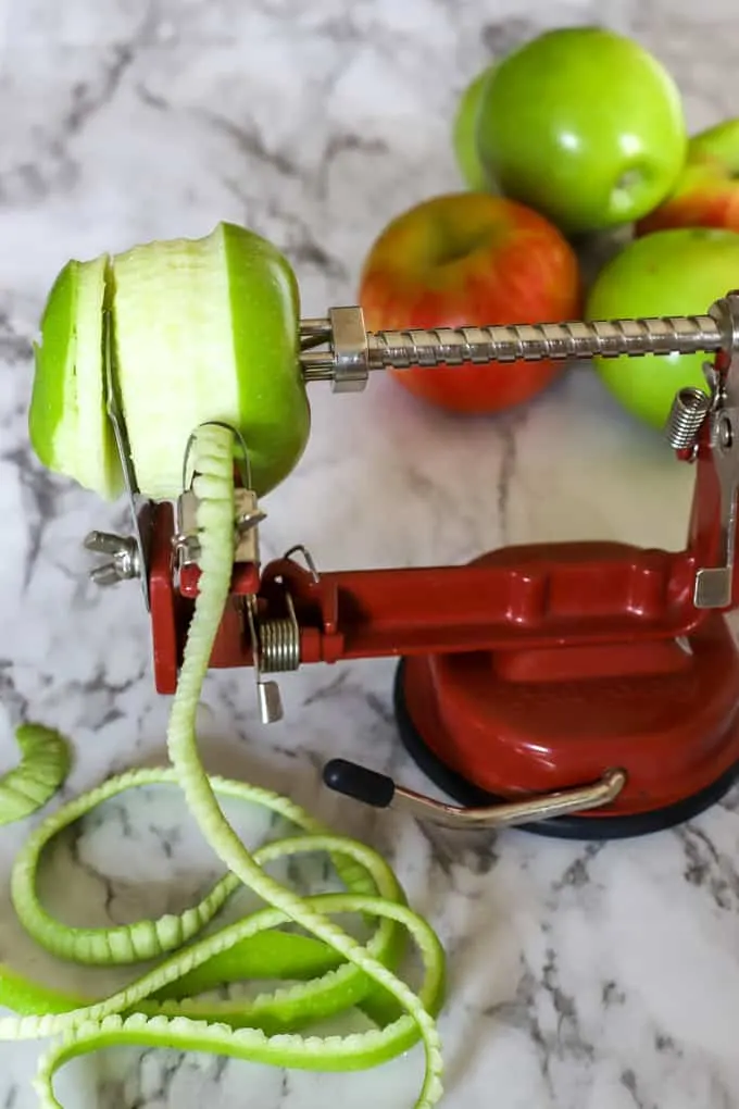 Apple peeling with apple corer and peeler with granny smith apple being peeled 