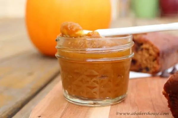 Pumpkin butter in a mason jar on wooden cutting board