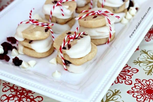 Stacks of white chocolate chip cookies on white serving plate