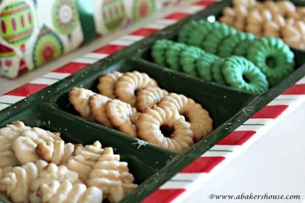 Christmas Spritz Cookies in the shape of trees and wreaths on a holiday serving tray