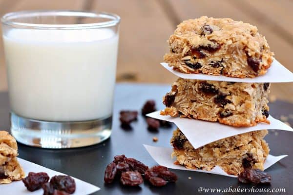 Stack of three oatmeal raisin bars and a glass of milk