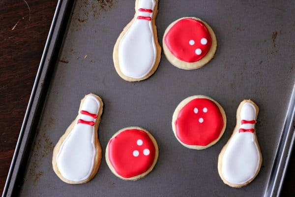 Cookies shaped like Bowling Ball and Pins on a metal baking sheet