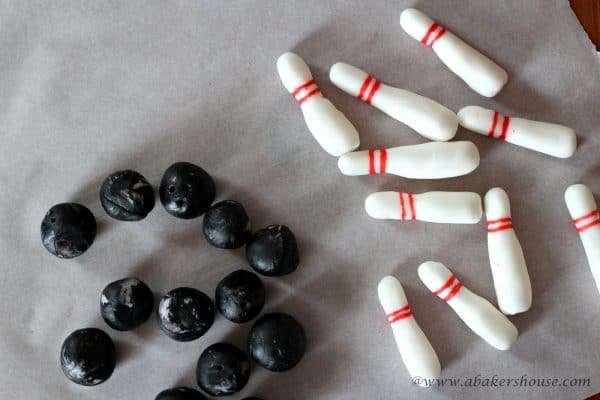 fondant bowling pins and balls on parchment paper