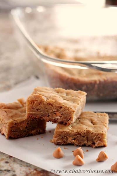 Three butterscotch blondie bars stacked on white parchment