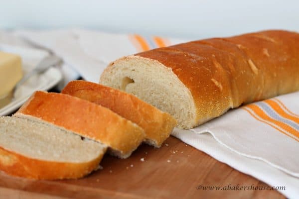 sliced loaf of French bread on wooden cutting board