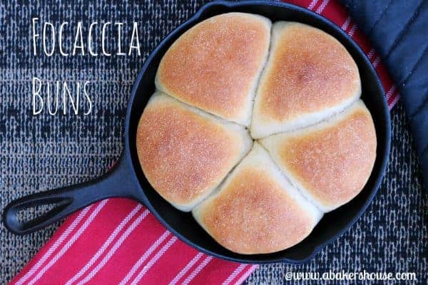 Focaccia rolls baked in a cast iron skillet on a red striped towel