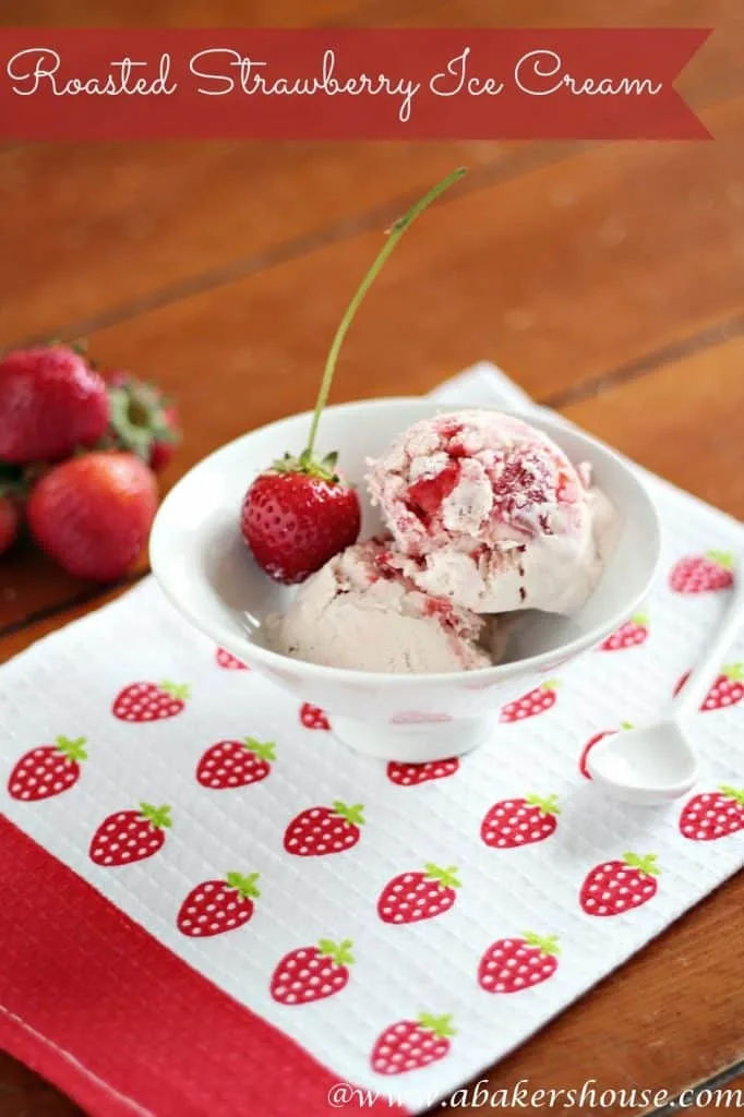 bowl of roasted strawberry ice cream on top of a white towel printed with strawberries