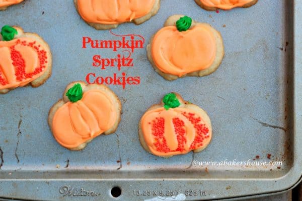 orange pumpkin decorated cookies on a metal baking pan