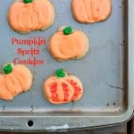 Pumpkin spritz cookies on a metal baking tray