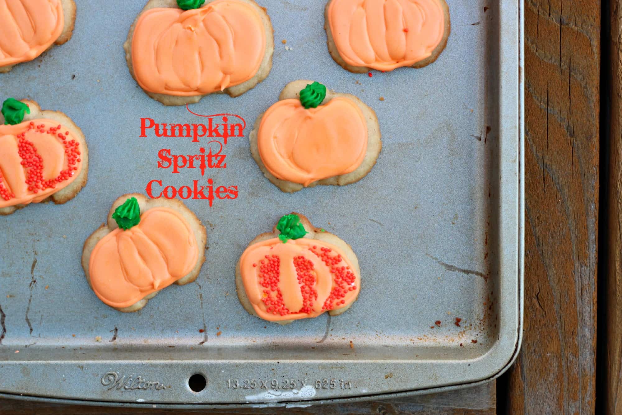 Pumpkin spritz cookies on a metal baking tray