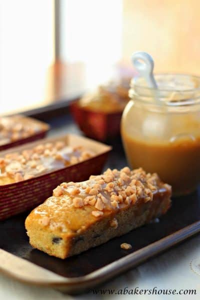 three mini toffee banana bread next to a jar of caramel