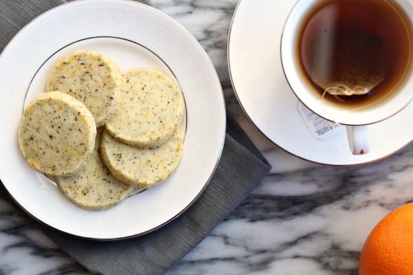 overhead view of five orange spiced tea cookies on a plate with cup of tea