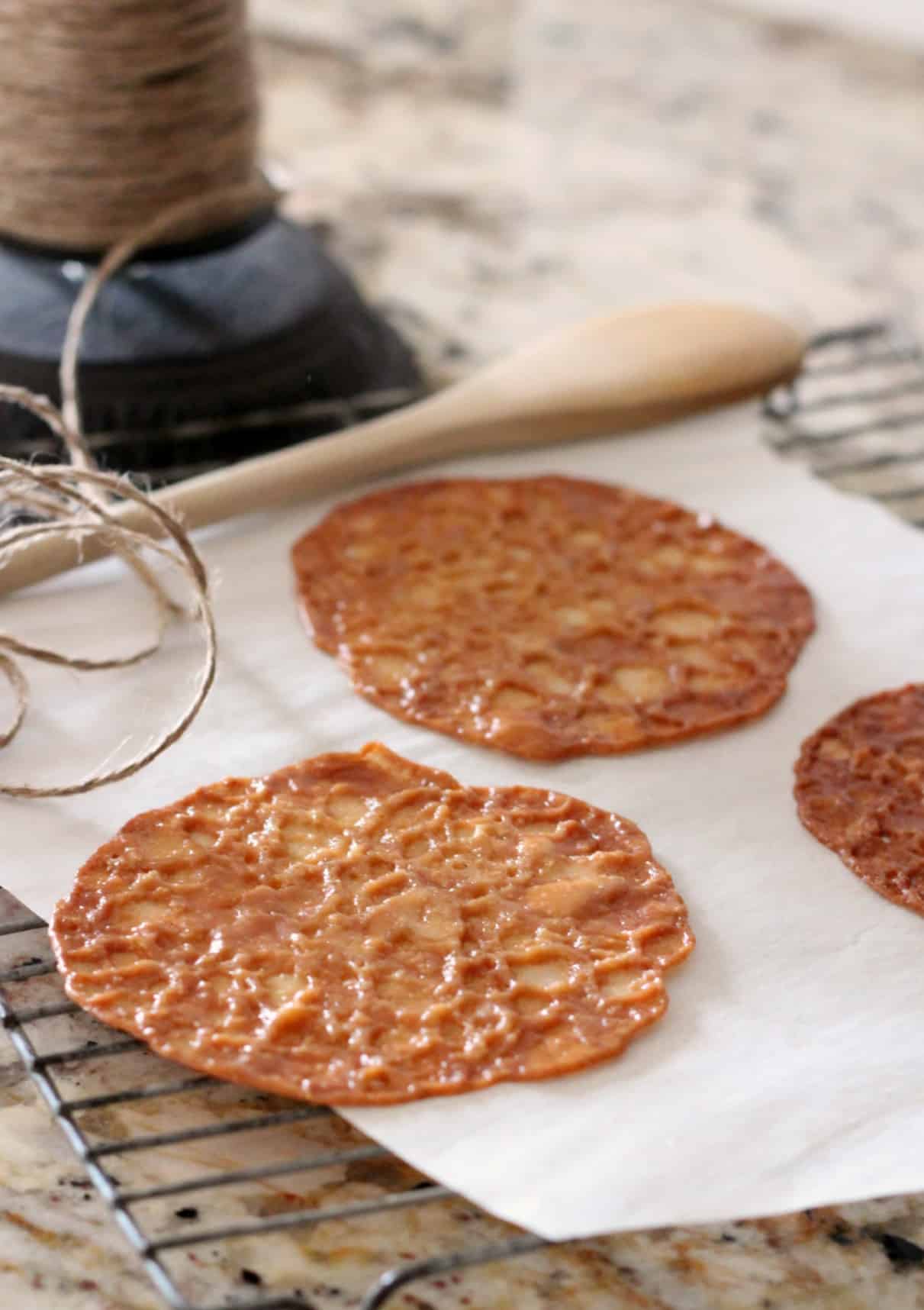Almond lace florentines on a white parchment with wire baking rack
