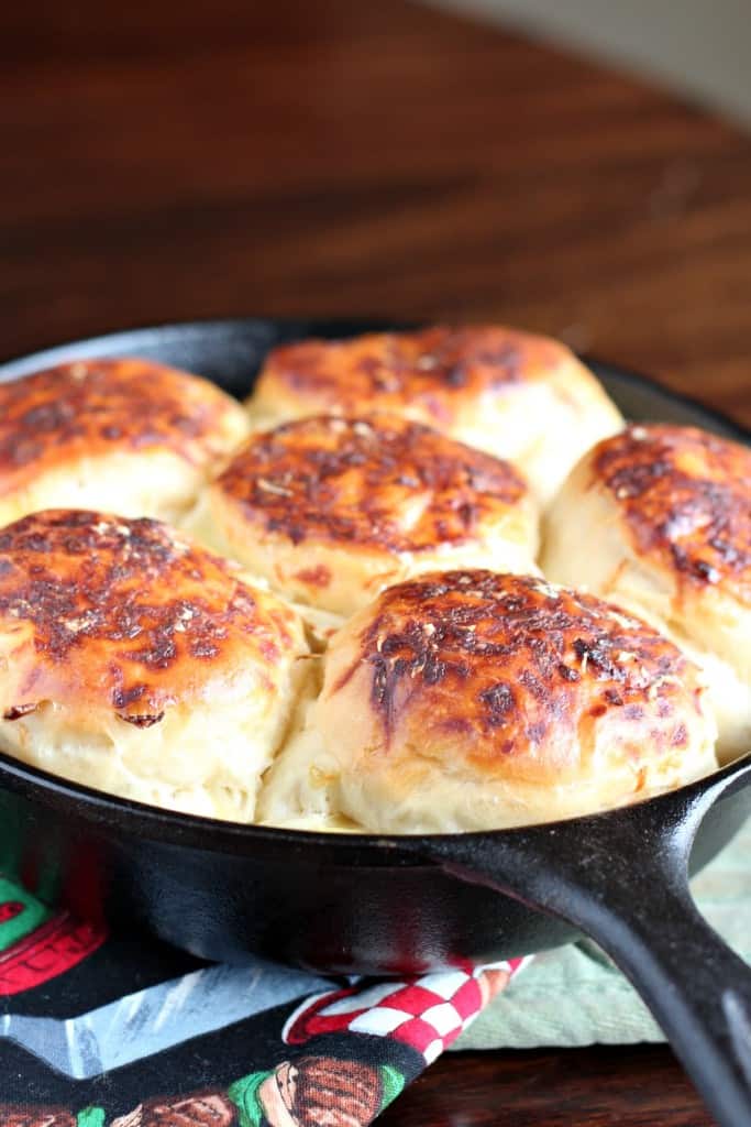 Six onion rolls baked in a round cast iron skillet