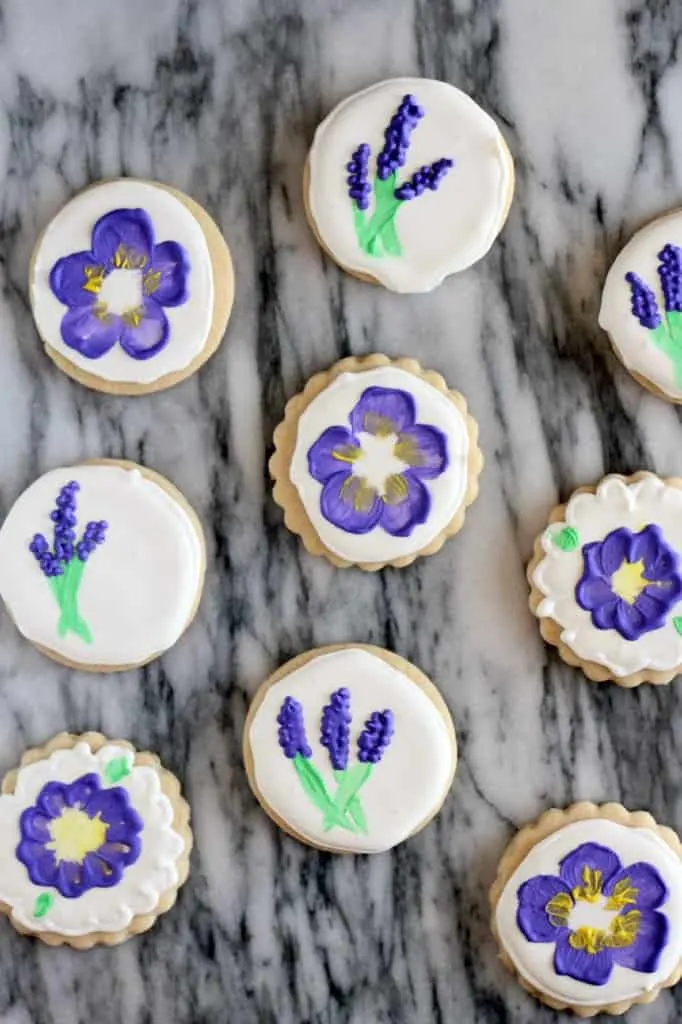 purple painted flower cookies on a marble tray