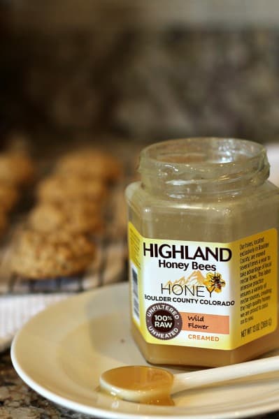 highland honey with spoonful on white plate and cookies in background