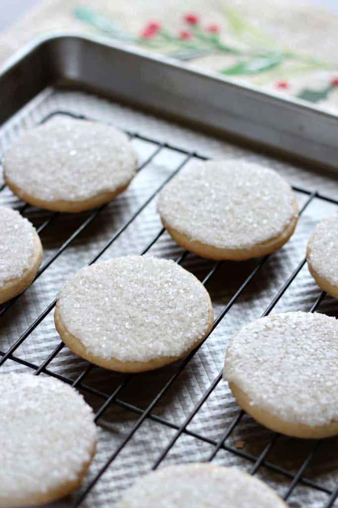 sugar cookies with sparking sugar on a cooling rack on a baking sheet