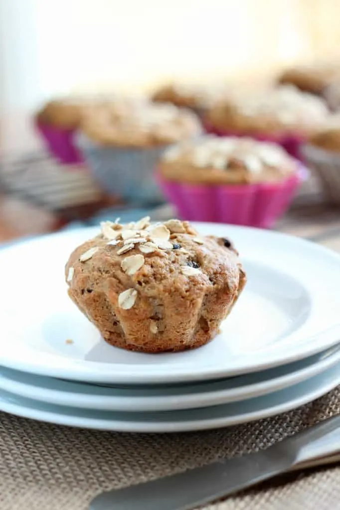 applesauce muffin with oat topping on stack of three white plates