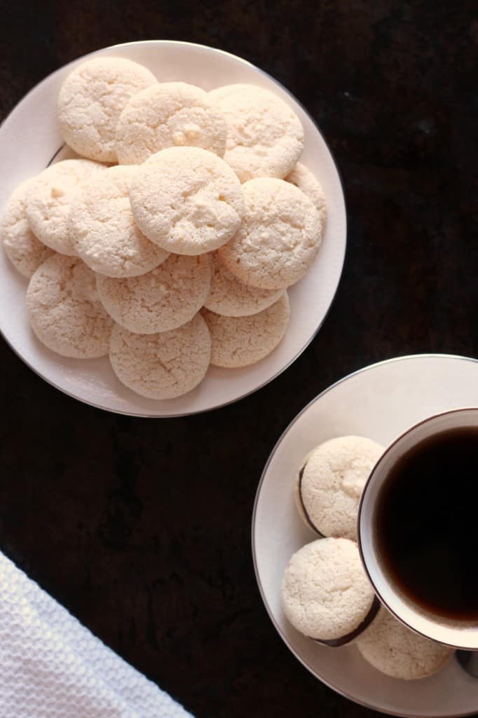 amaretti biscuits on a plate near a cup of coffee
