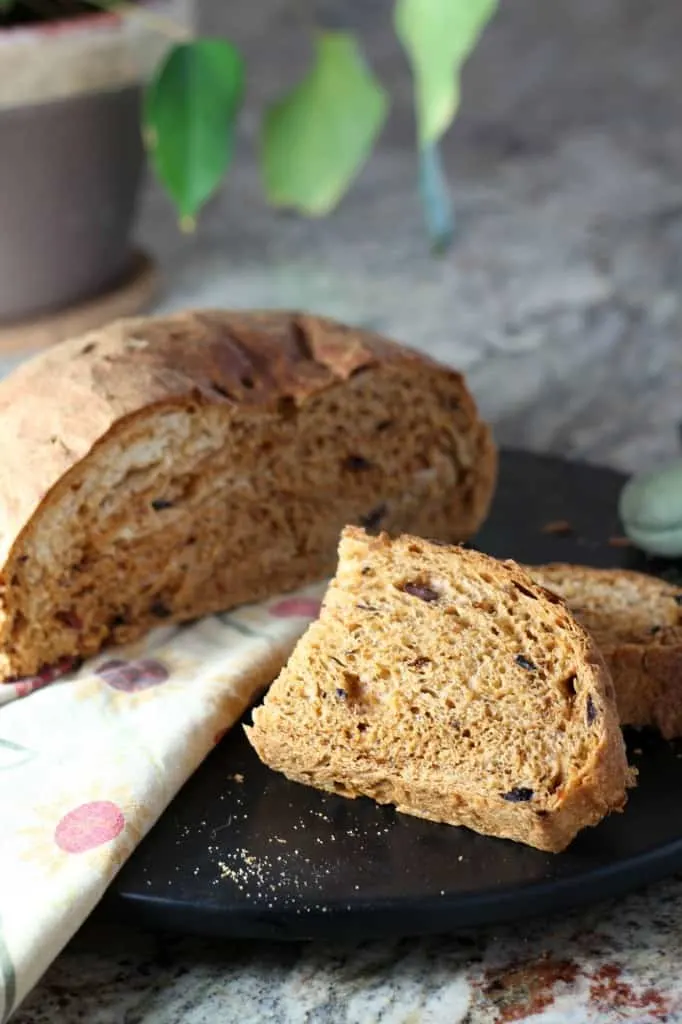 round loaf of sun dried tomato and olive bread sliced in half