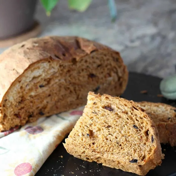 sun dried and tomato bread sliced in half on cutting board