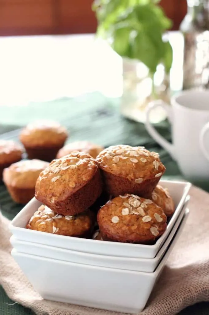 honey oatmeal muffins piled in a square white serving dish