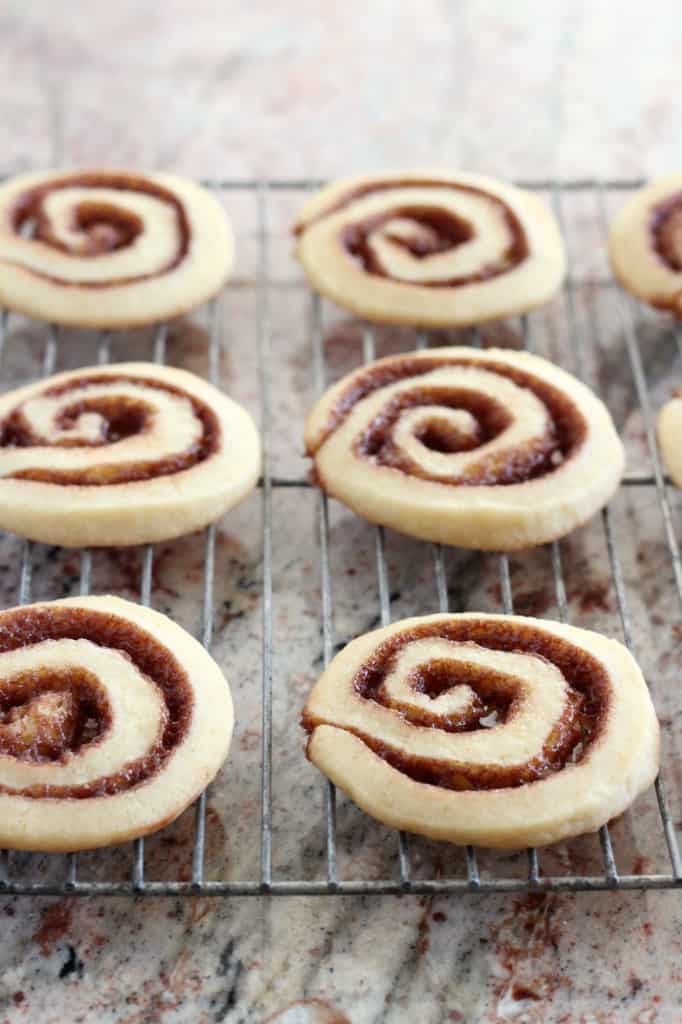 Six cinnamon roll cookies on a wire baking rack