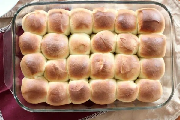 Twenty four baked classic dinner rolls in glass baking dish