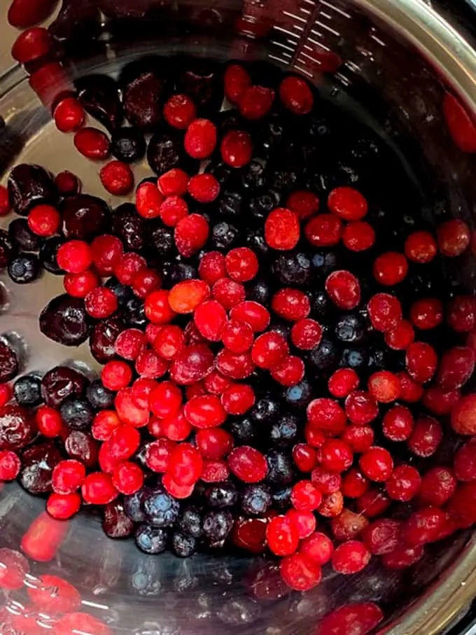 Frozen berries are in the Instant Pot for making wojapi