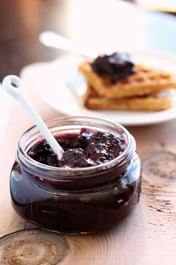 wojapi in a glass jar with wojapi topped waffles in background