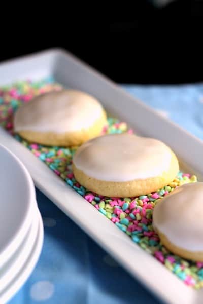 lemon meltaway cookies on a bed of pastel sprinkles on white plate