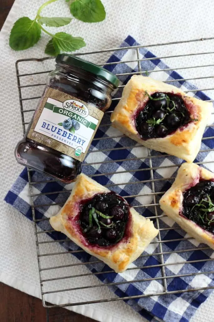 Sprouts Organic Preserves Blueberry Tarts on wire rack with jar of blueberry preserves