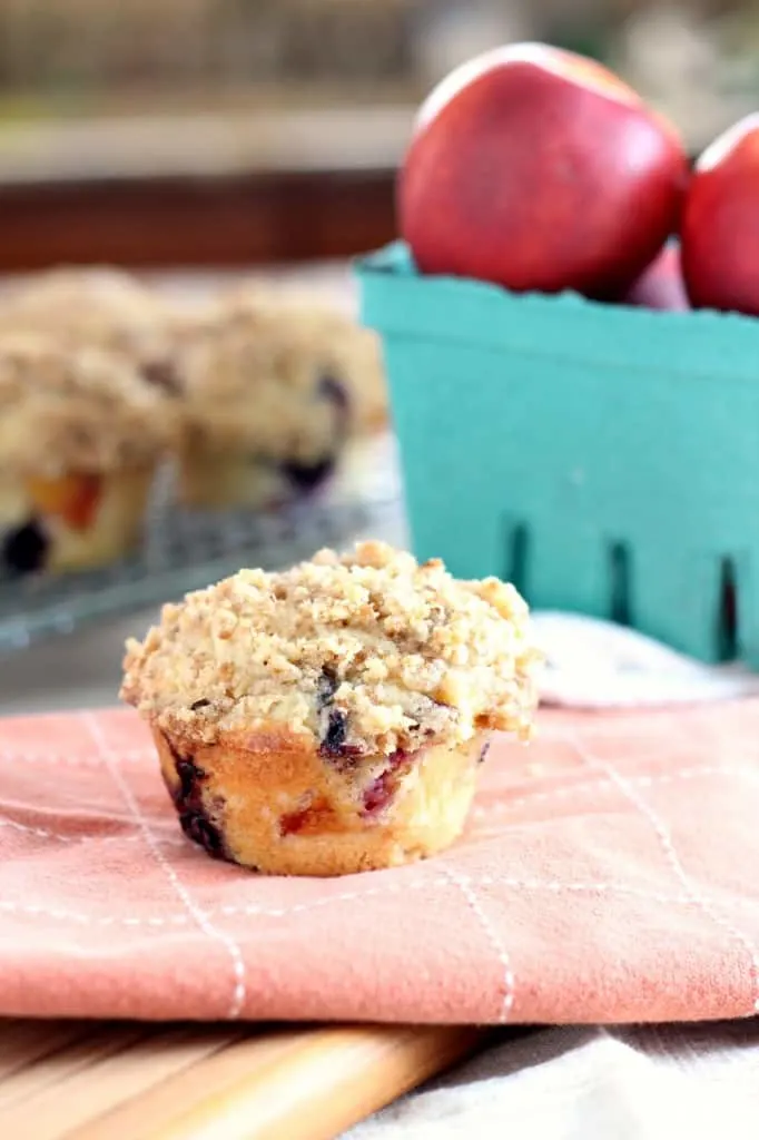 nectarine blueberry muffin on towel with nectarines on the side