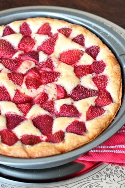 cake baked in metal pan with strawberries baked on top