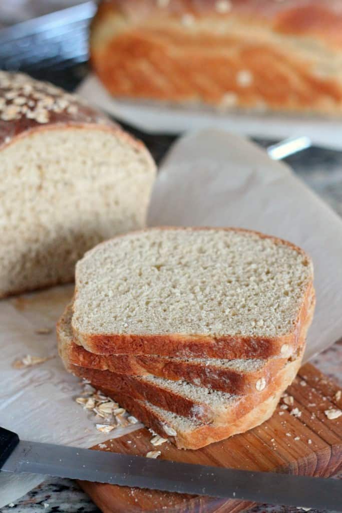 slices of maple oatmeal bread with loaf of bread in background