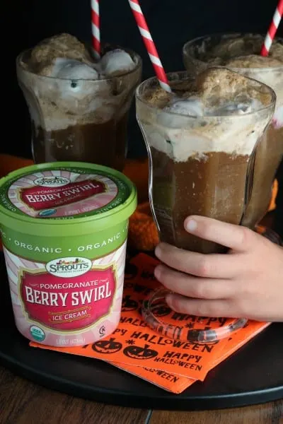 Sprouts berry swirl ice cream in a root beer float held by child's hand