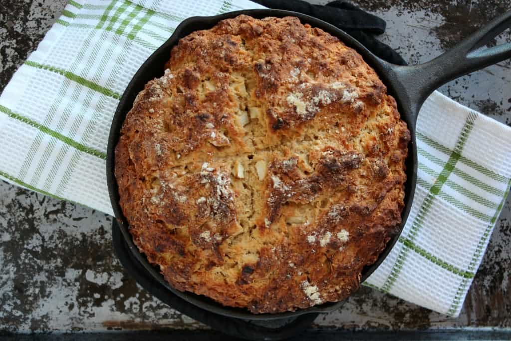 beer soda bread in cast iron skillet on green and white towel