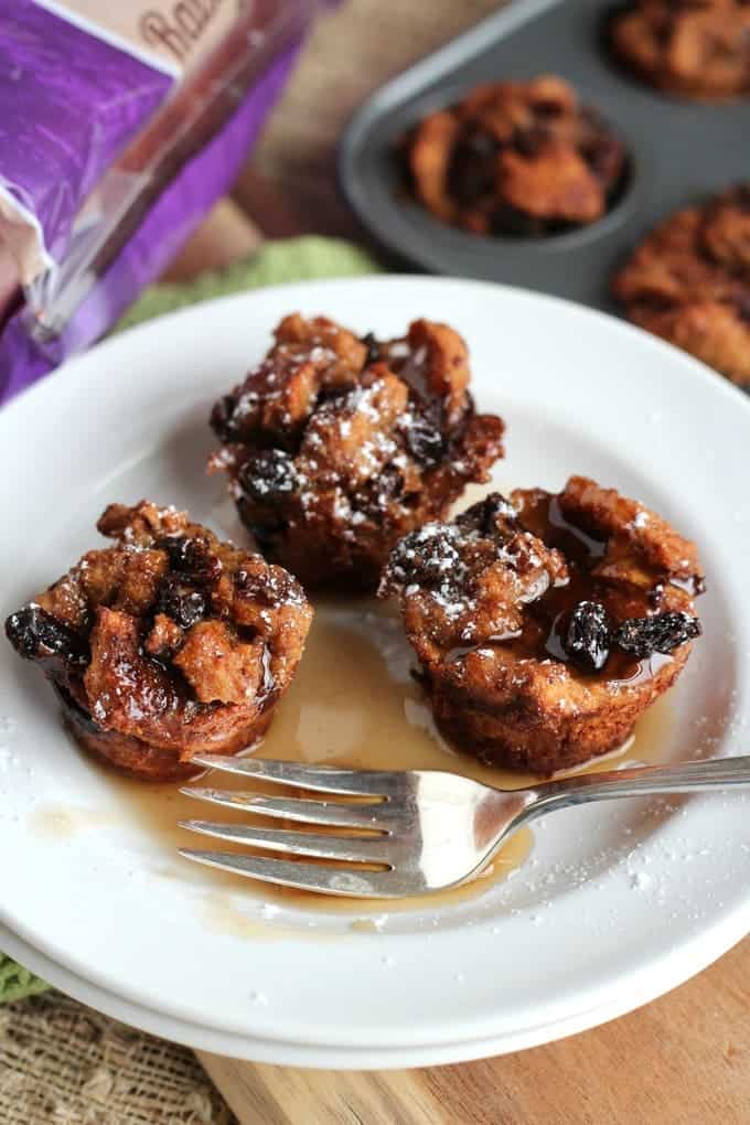 French toast muffins with raisins on white plate with syrup and fork