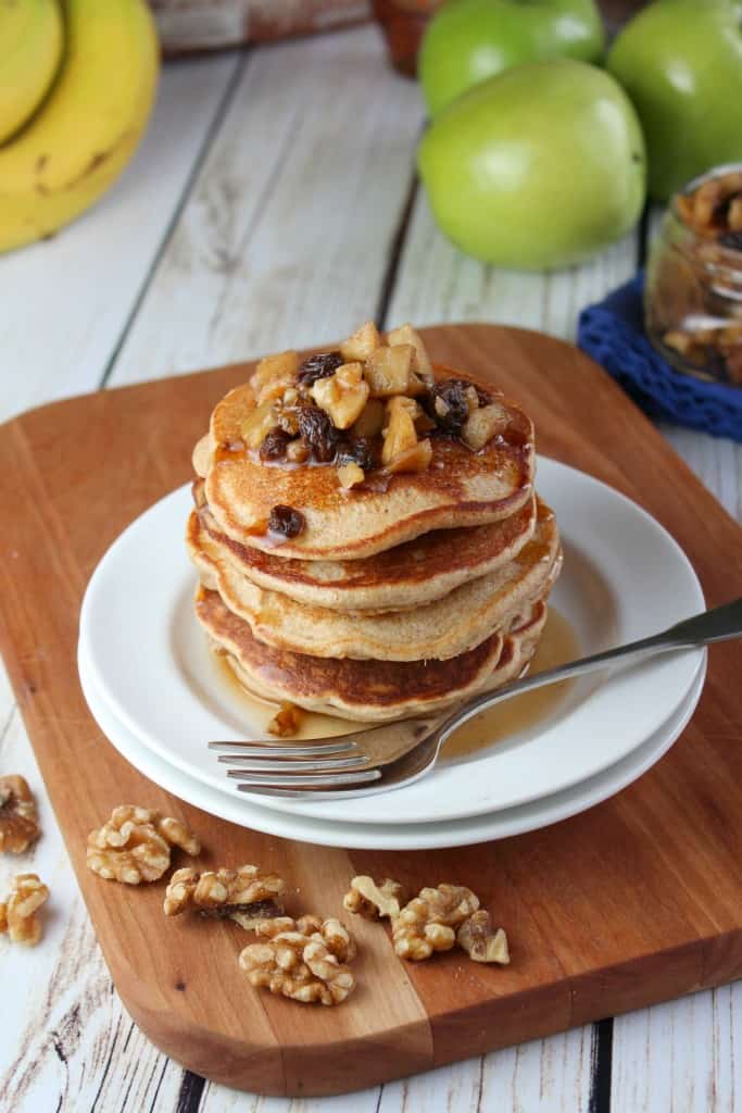 banana walnut pancakes on white plate and brown cutting board