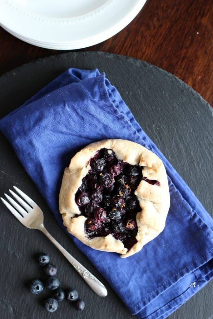blueberry galette gluten free on a blue napkin on top of a gray slate