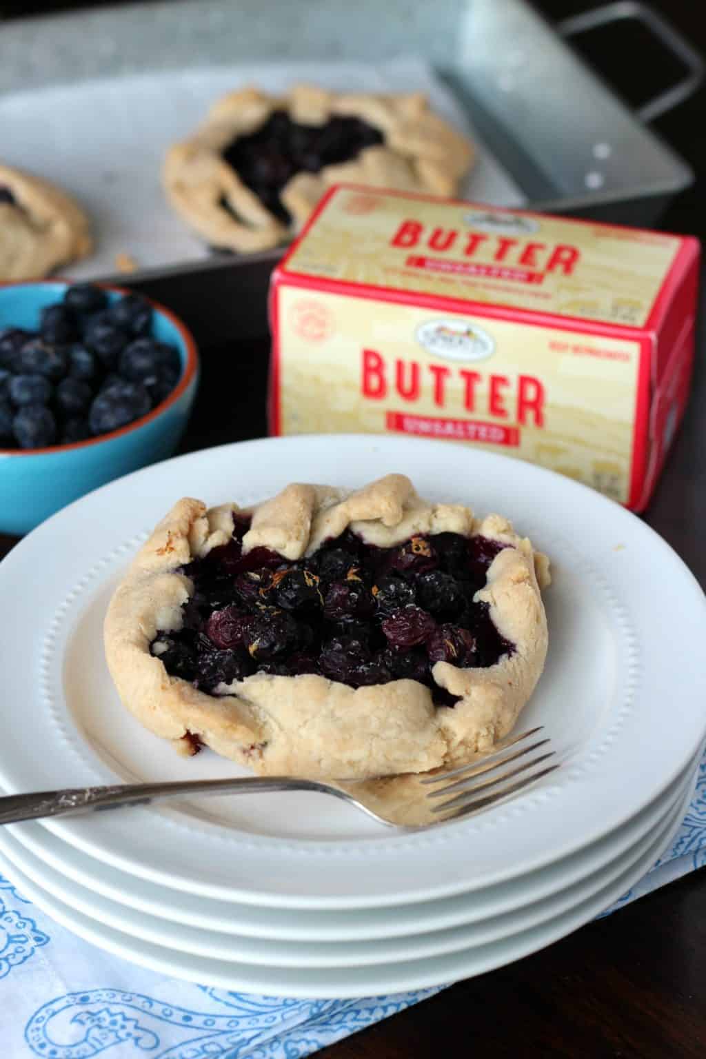 Blueberry galette on a white plate with Sprouts farmers market butter