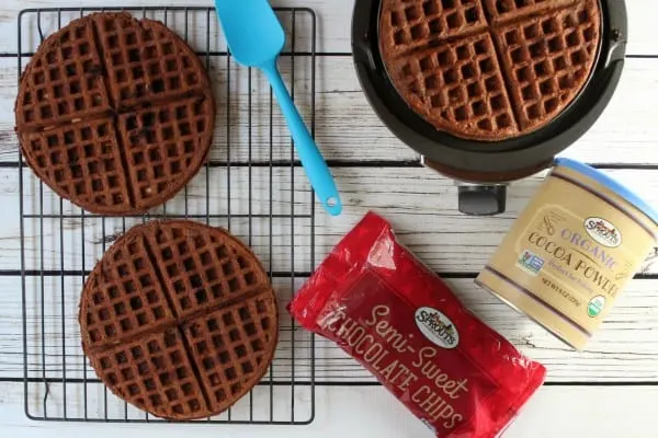 Chocolate waffles in a waffle iron with chocolate chips